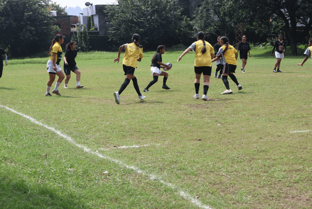 Live rugby match gameplay with Uttarakhand athletes running and passing ball